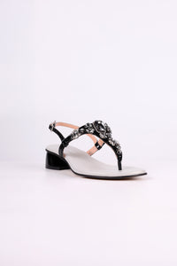Black sandal low heel with black straps and embellishments on a white background