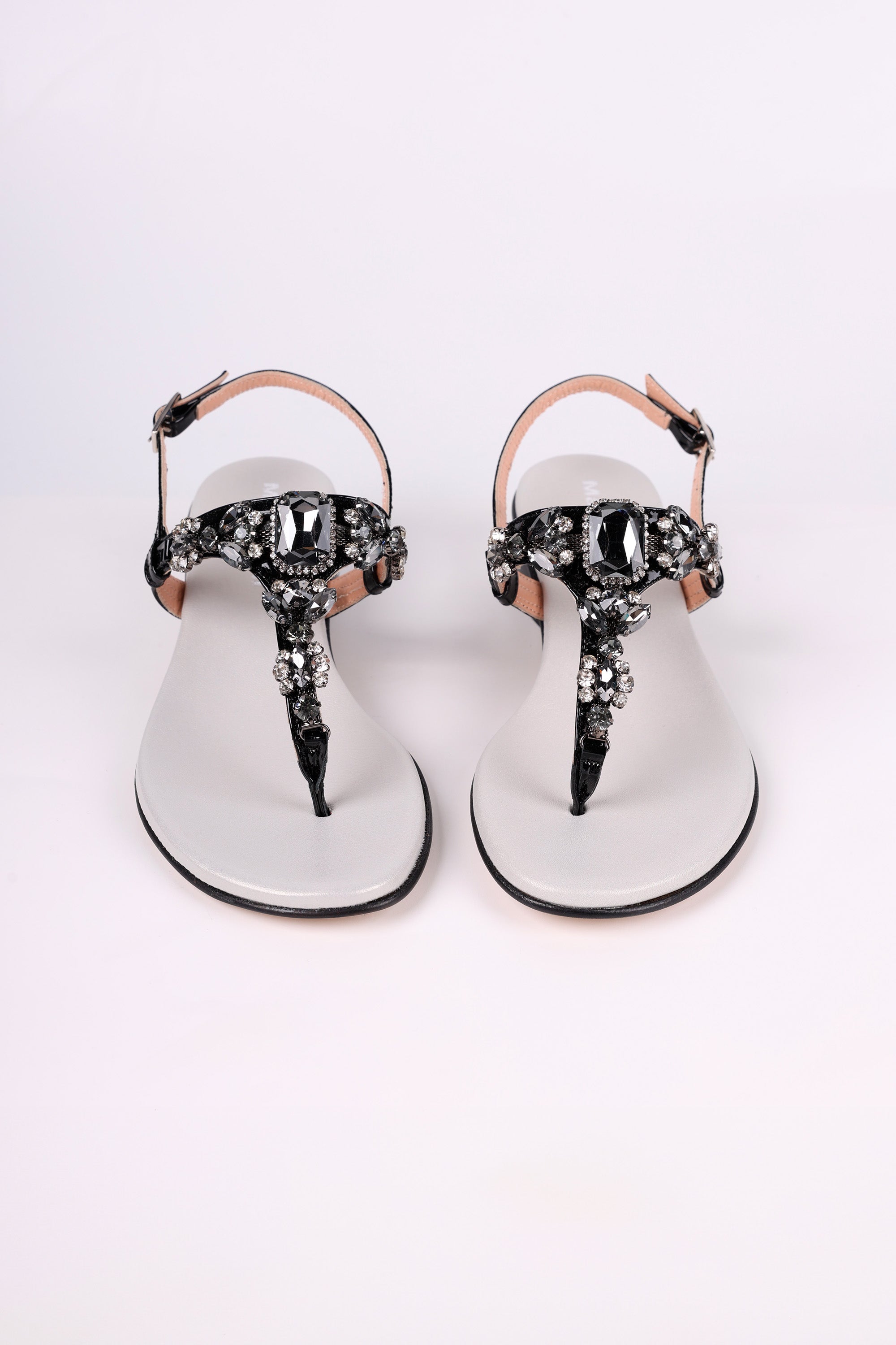 Pair of Black sandals with black low heels embellishments on a white background