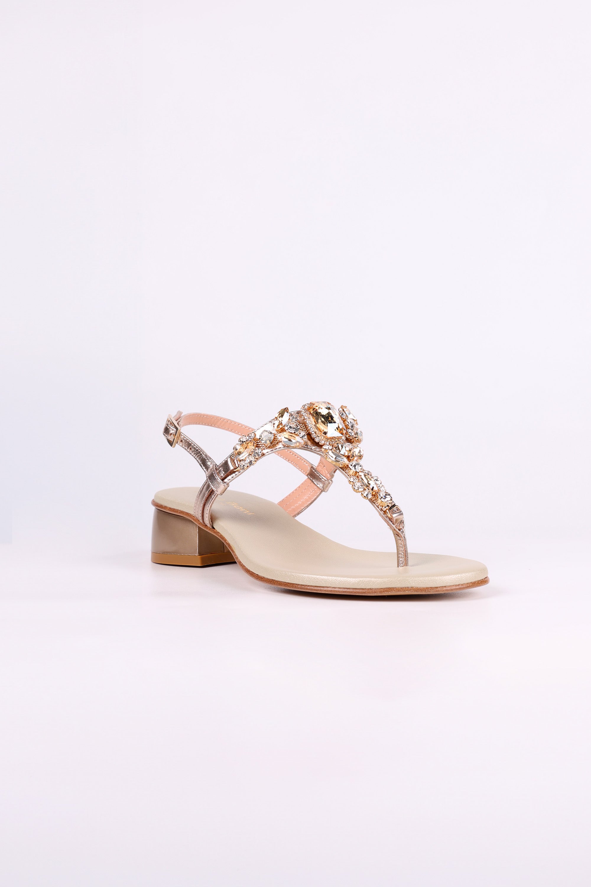 Platinum  sandal low heels with decorative straps on a white background