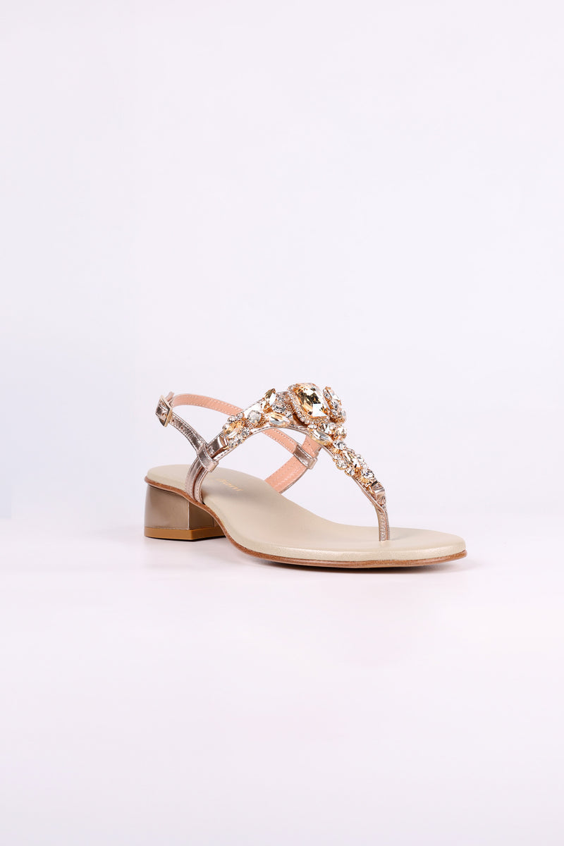 Platinum  sandal low heels with decorative straps on a white background