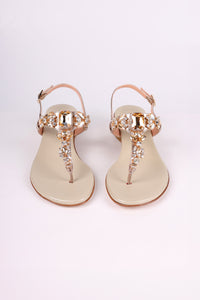 Pair of Platinum  sandals low heels with gold embellishments on a white background