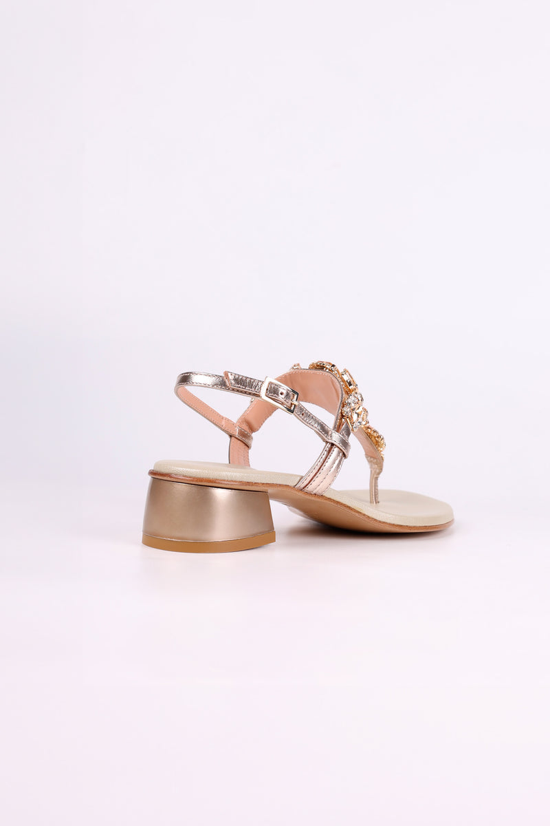 Platinum sandal low heels with a decorative strap on a white background