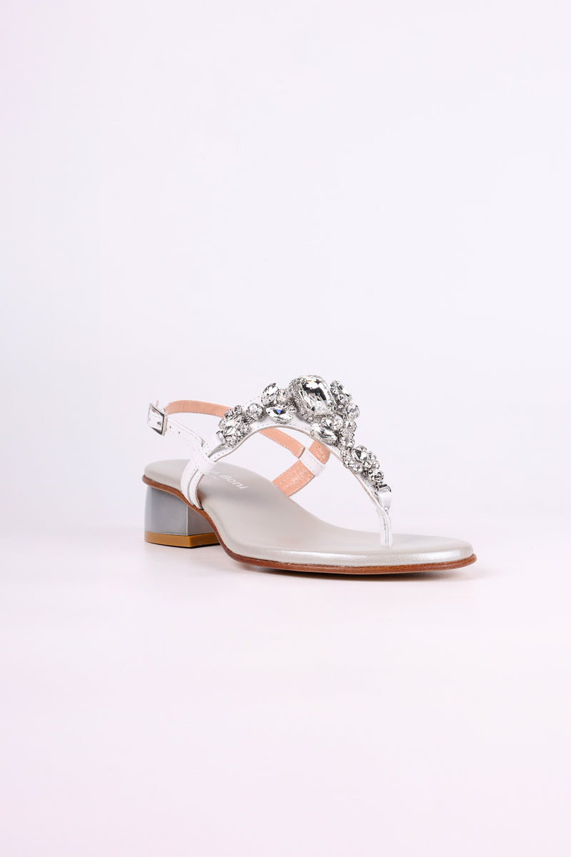 White sandal low heels with decorative straps and embellishments on a white background