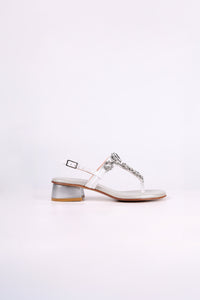 White sandal low heels 
with a silver strap on a white background