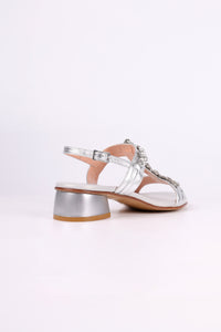 Silver low heels  sandals with clear straps on a white background